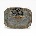 Silver western buckle with a gold longhorn skull, ornate scrollwork, and feather accents.
