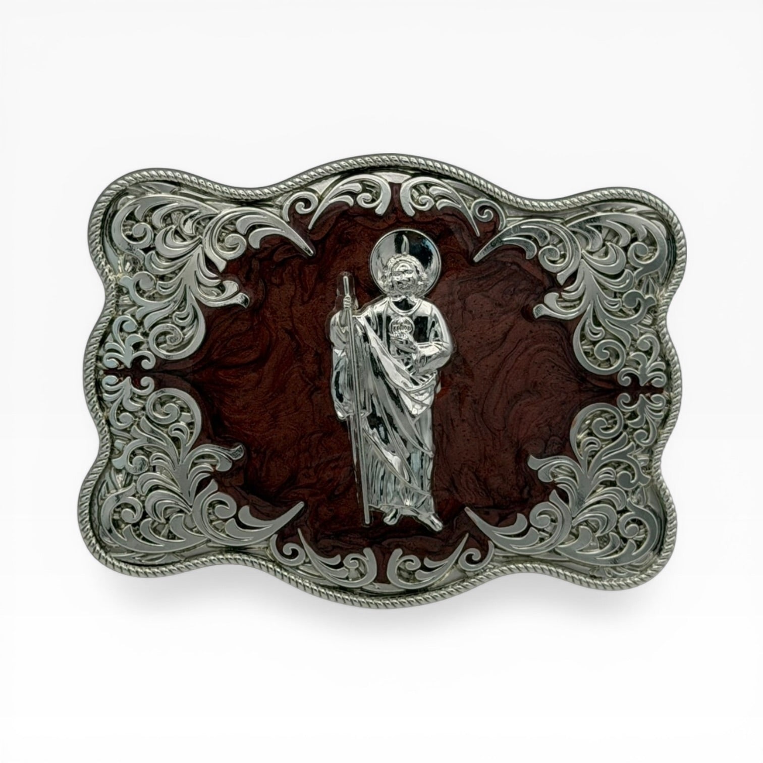 San Judas Tadeo silver buckle with mahogany wood-tone background and ornate filigree.
