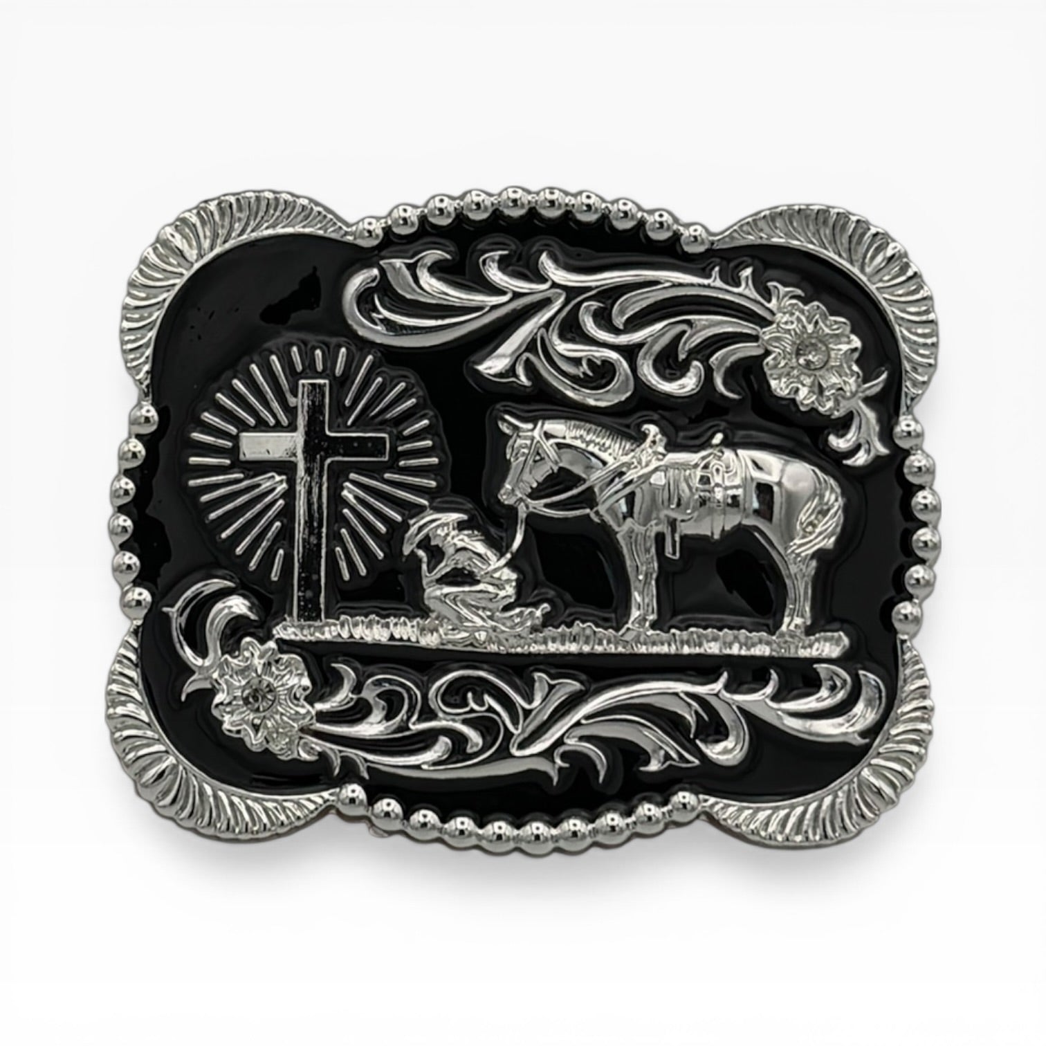Black and silver scalloped buckle with a kneeling cowboy, horse, and radiant cross design.
