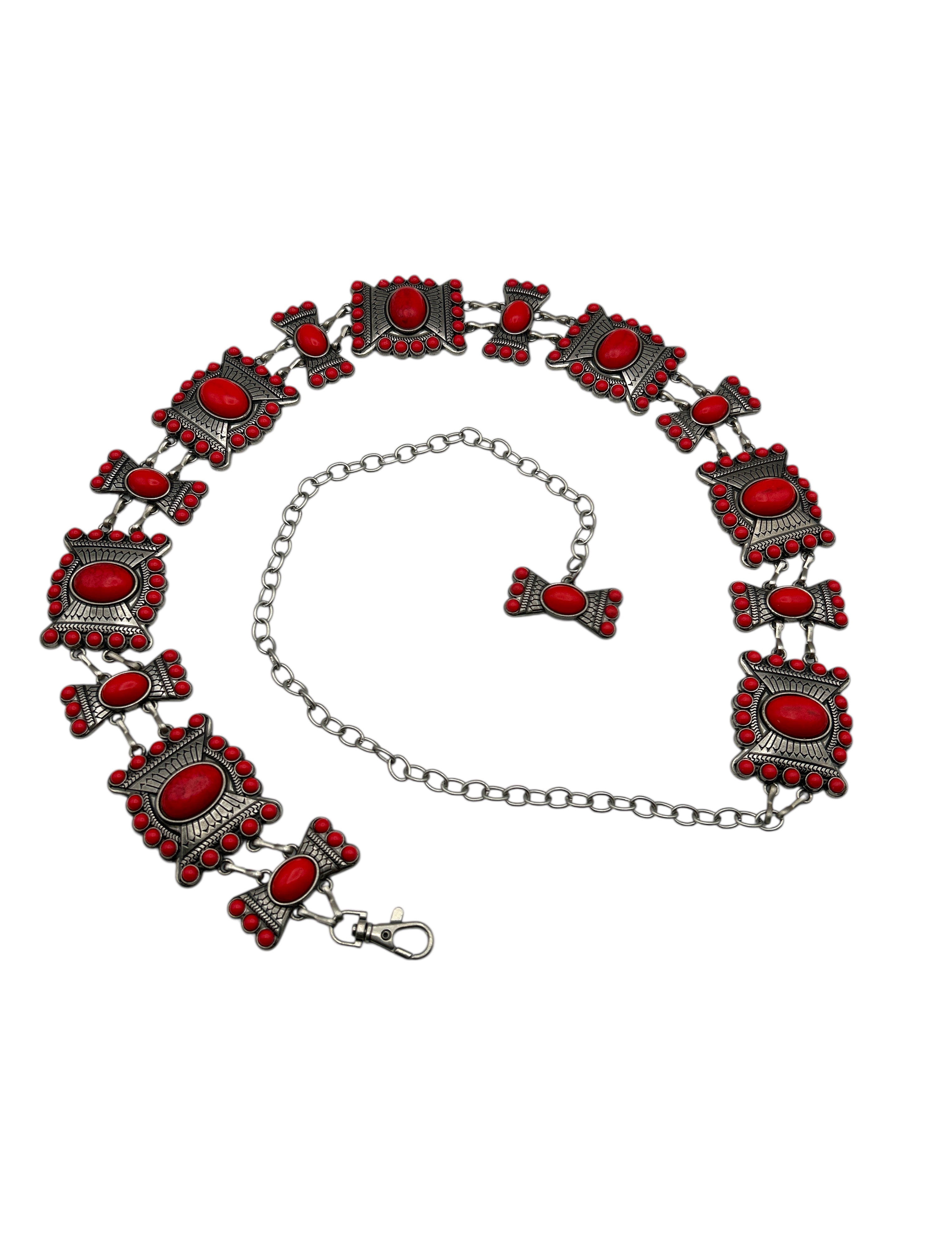 Silver Western metal concho belt with intricate red stone details and an adjustable chain.