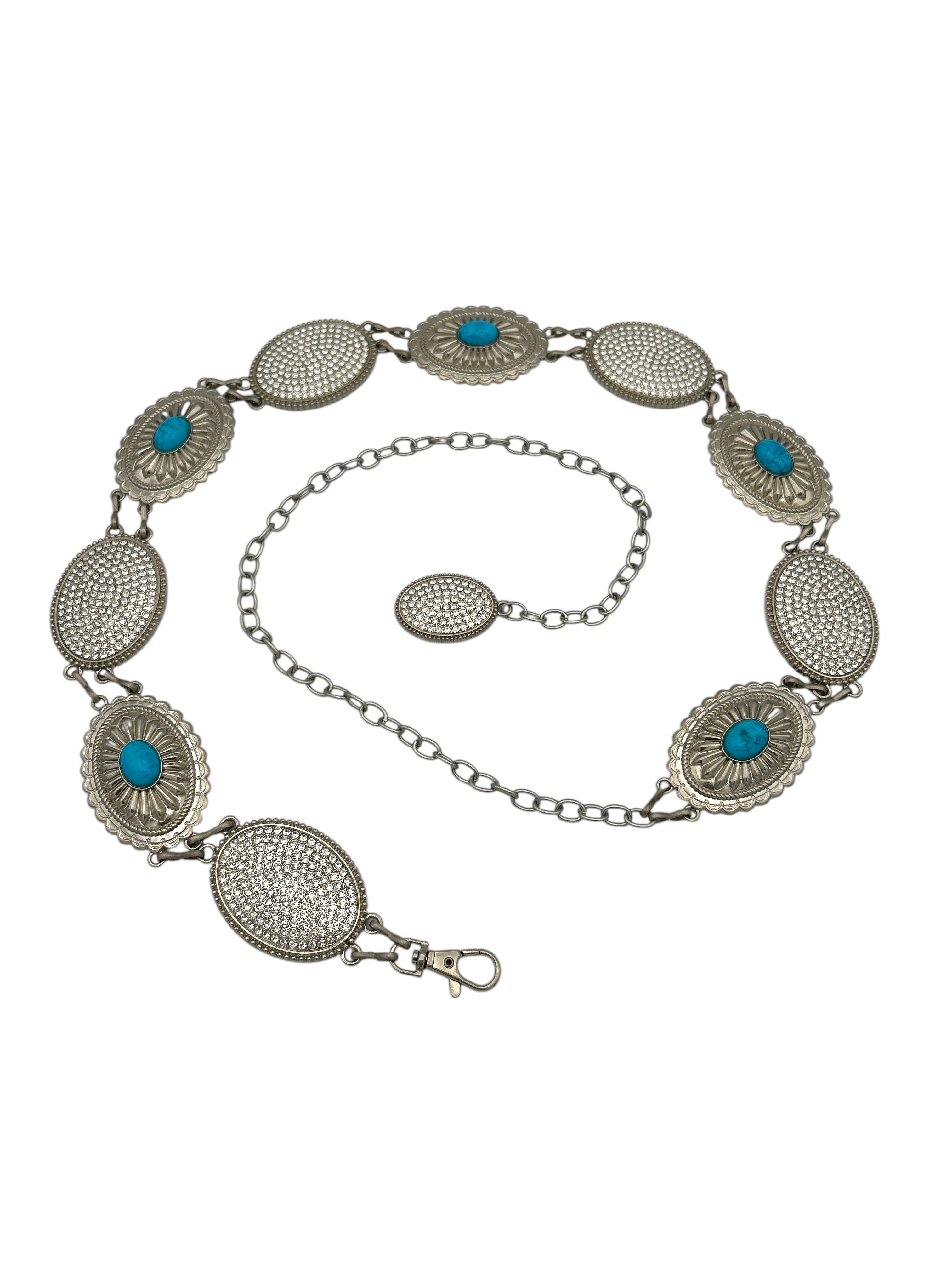 Silver Western metal concho belt with oval, intricately engraved conchos, some featuring turquoise stones.