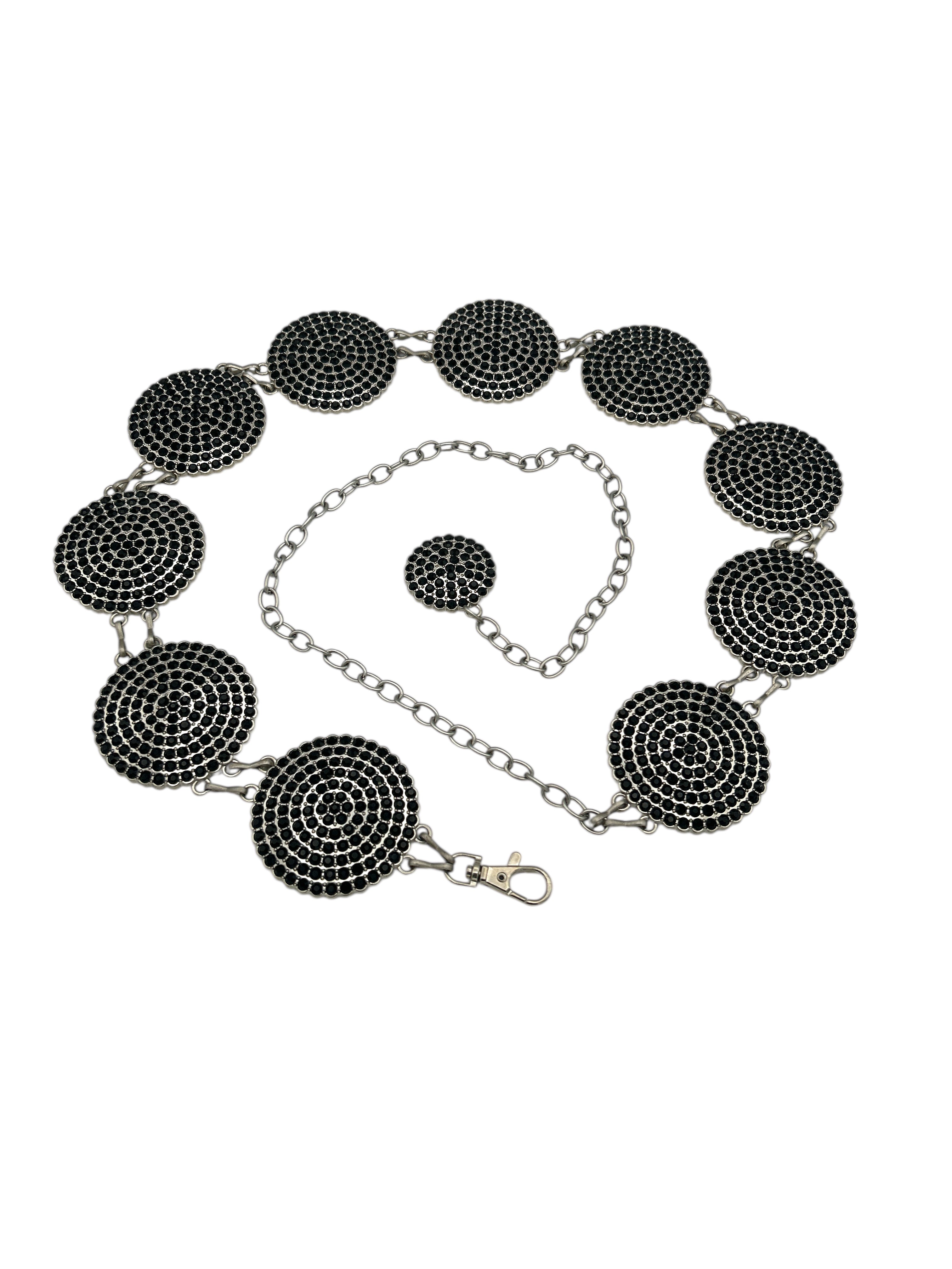 Silver metal concho belt with round, black intricately engraved conchos and an adjustable chain.