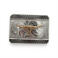 Silver belt buckle with a gold longhorn, western scroll engraving, and a black patterned border.