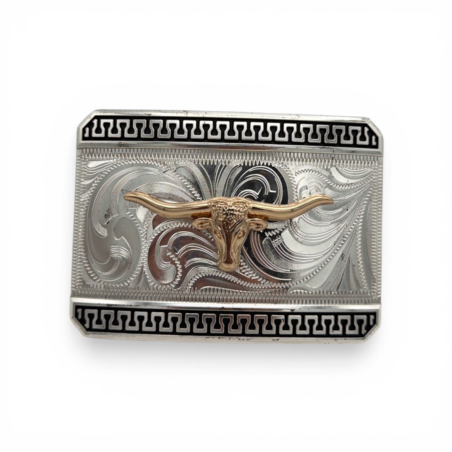 Silver belt buckle with a gold longhorn, western scroll engraving, and a black patterned border.