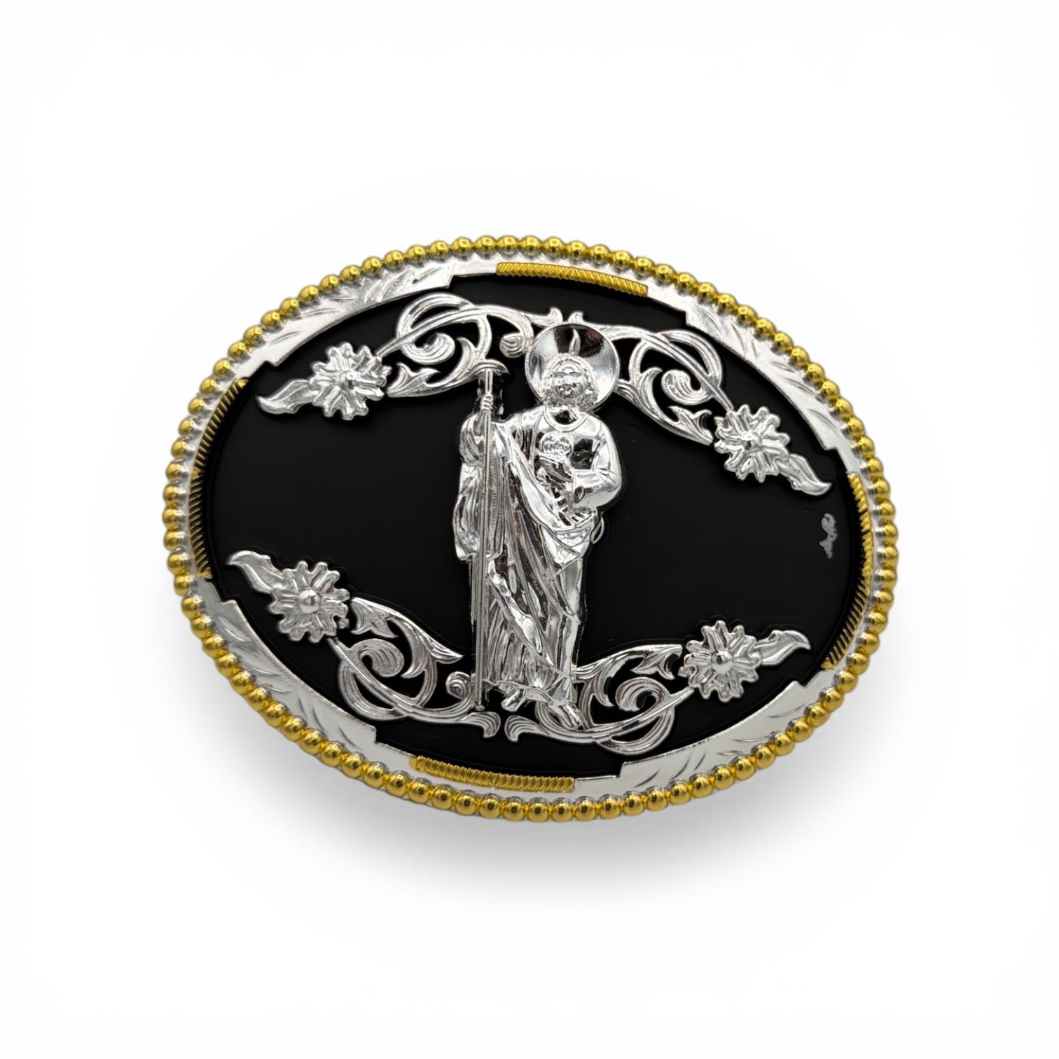 Silver San Judas belt buckle with black background, gold beaded border, and western floral scrollwork.