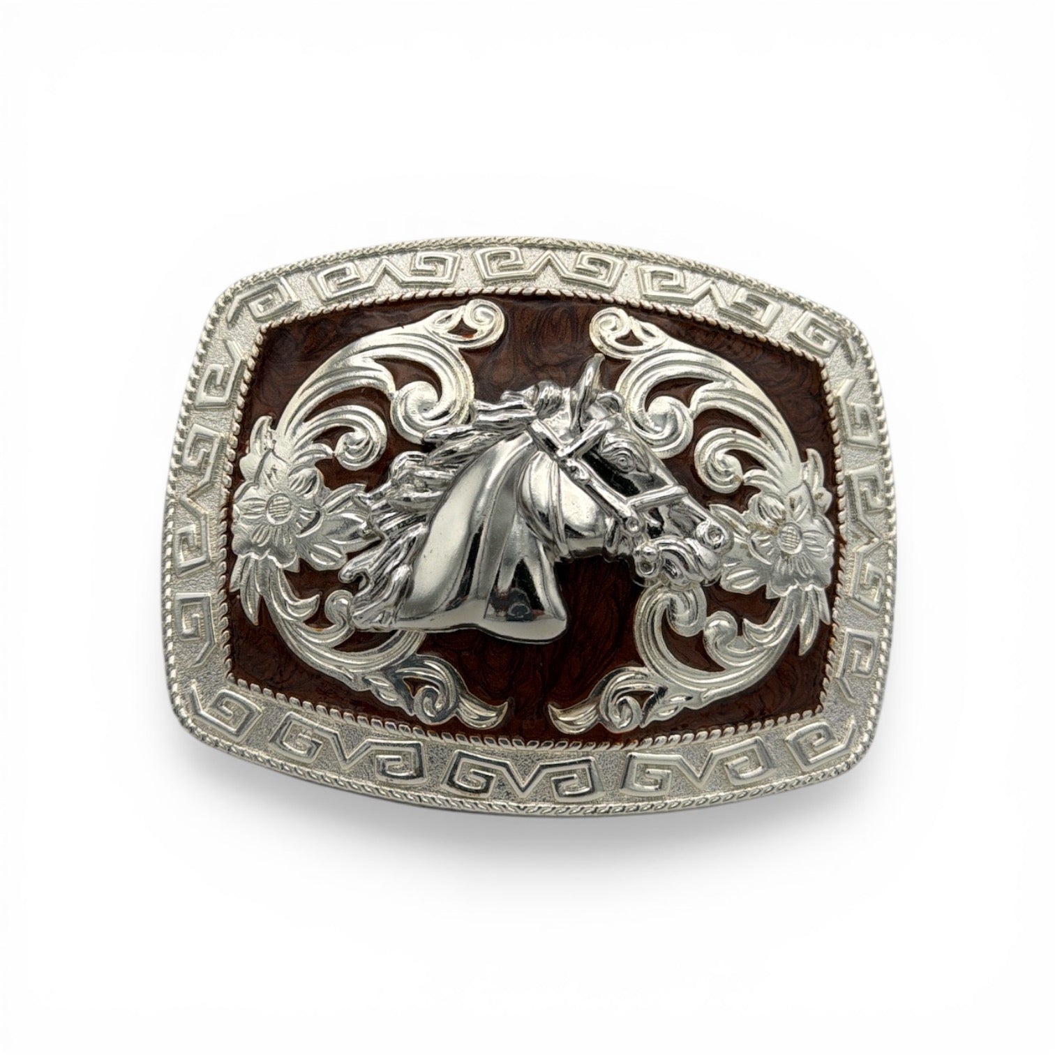 Silver tone western buckle with detailed horse head, scrollwork, and a deep brown background.