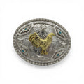Oval silver western buckle with gold rooster, scrollwork, stars, turquoise stones, and beaded border.