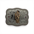 Two-tone gold and silver western buckle with a Saint Jude figure, scroll engraving, horse silhouettes, and pink stone border.