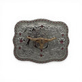 Silver western buckle with a gold longhorn skull, ruby red stones, and scrollwork.