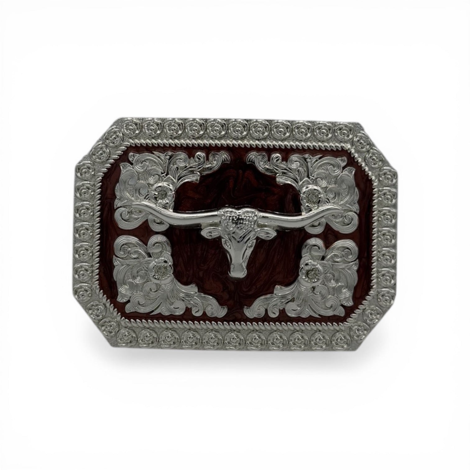 Silver longhorn skull buckle with dark woodgrain background, western scroll engravings, and rope edge.