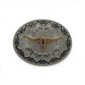 Oval two-tone metal buckle with gold longhorn head, silver scrollwork, and black Aztec border.